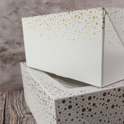 weißer Tortenkarton mit goldenen Punkten